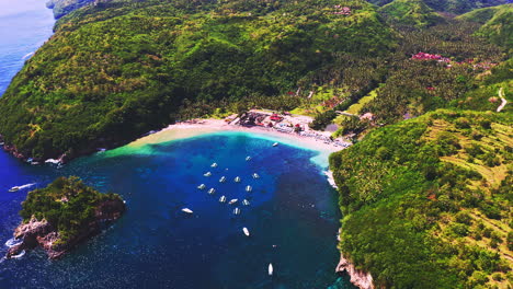 fleet of boats anchoring in crystal bay beach next to tropical valley