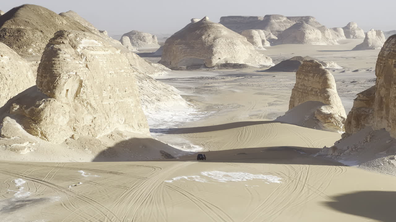 The Egyptian white desert adventure tourism with bedouin camping and 4x4 driving through the desert to see rock formation and sand and dust at sunset and golden hour