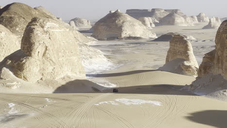 the egyptian white desert adventure tourism with bedouin camping and 4x4 driving through the desert to see rock formation and sand and dust at sunset and golden hour