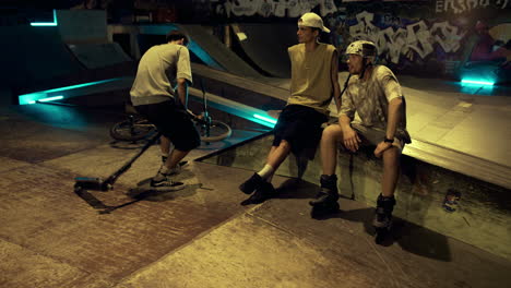 Relaxed-friends-communicating-together-in-skate-park-with-graffiti-wall.