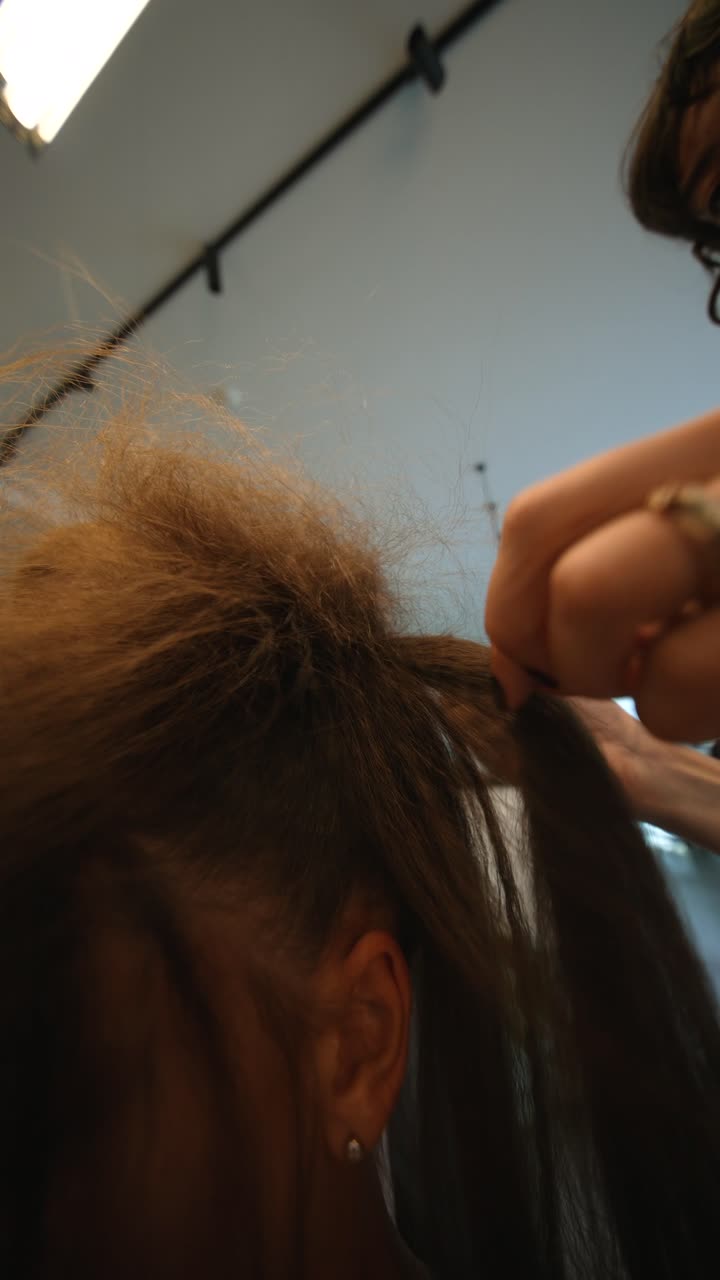 Primo piano di una donna che si fa cotonare i capelli in un salone