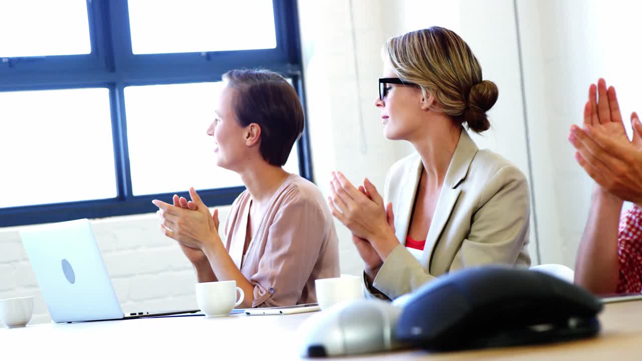 임원 들 이 회의 에서 박수 를 치고 있다