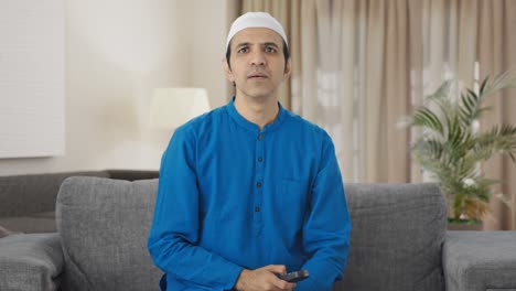 muslim man watching television at home