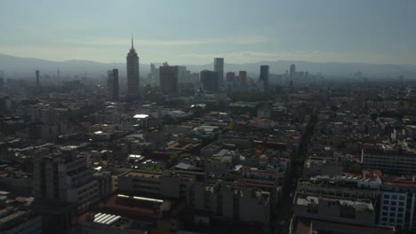 drone asciende para revelar el horizonte de la ciudad de méxico en segundo plano en un día brumoso
