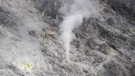 sulfur smoke coming out of rocks in volcano in north sumatra, indonesia