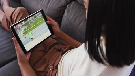 composite of woman on couch at home watching athletics high jump event on tablet