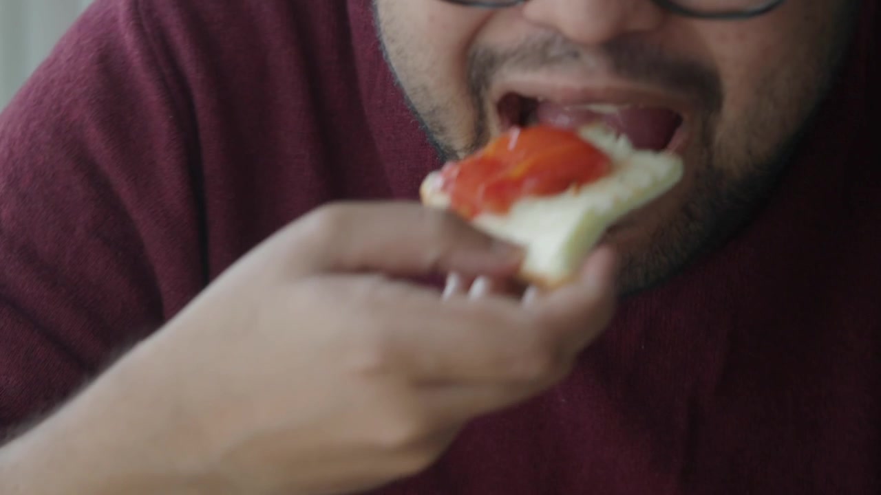 Man Eating a Slice of Pizza