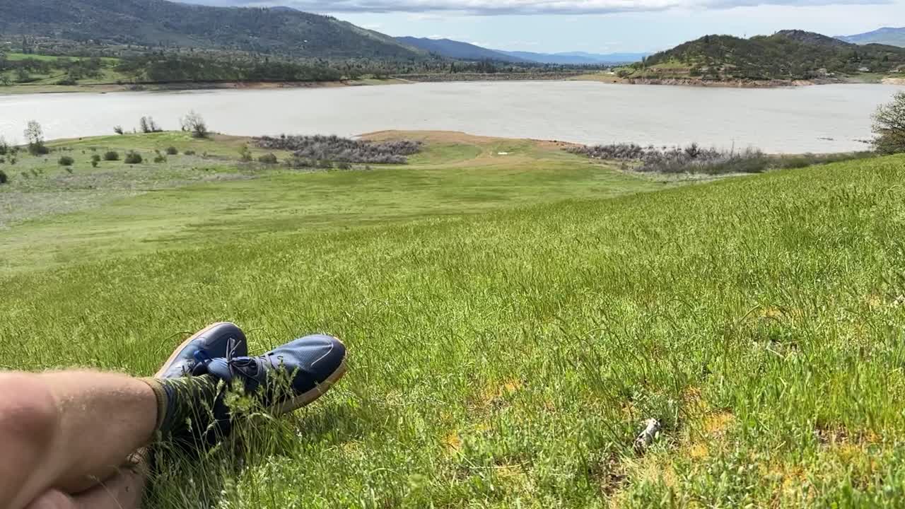 View of some legs relaxing on the grassy hillside next to Emigrant Lake in Oregon