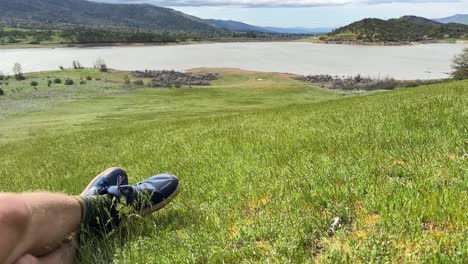 view of some legs relaxing on the grassy hillside next to emigrant lake in oregon