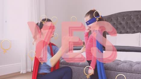 Animation-of-yes-text-over-superhero-mother-and-daughter