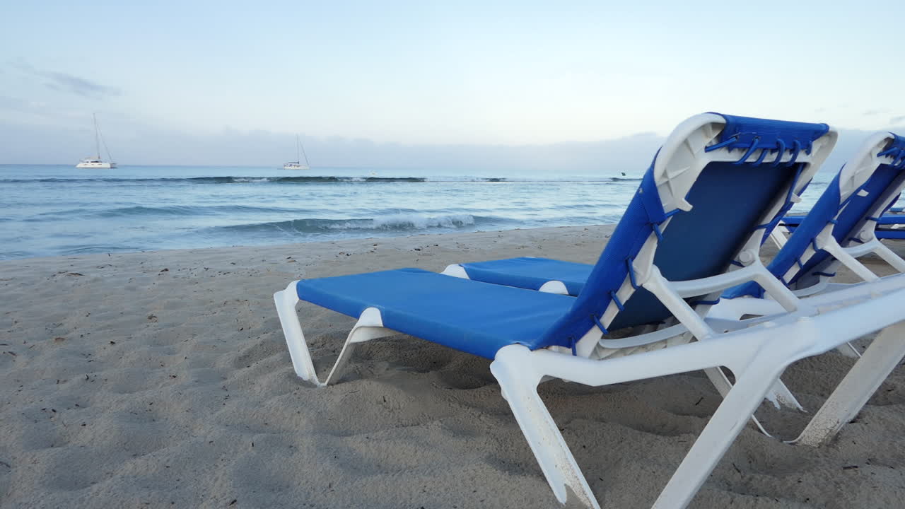 誰もいないビーチのサンベッドの後ろからの眺め、海の小さな波、夢のような贅沢な旅行のインスピレーション