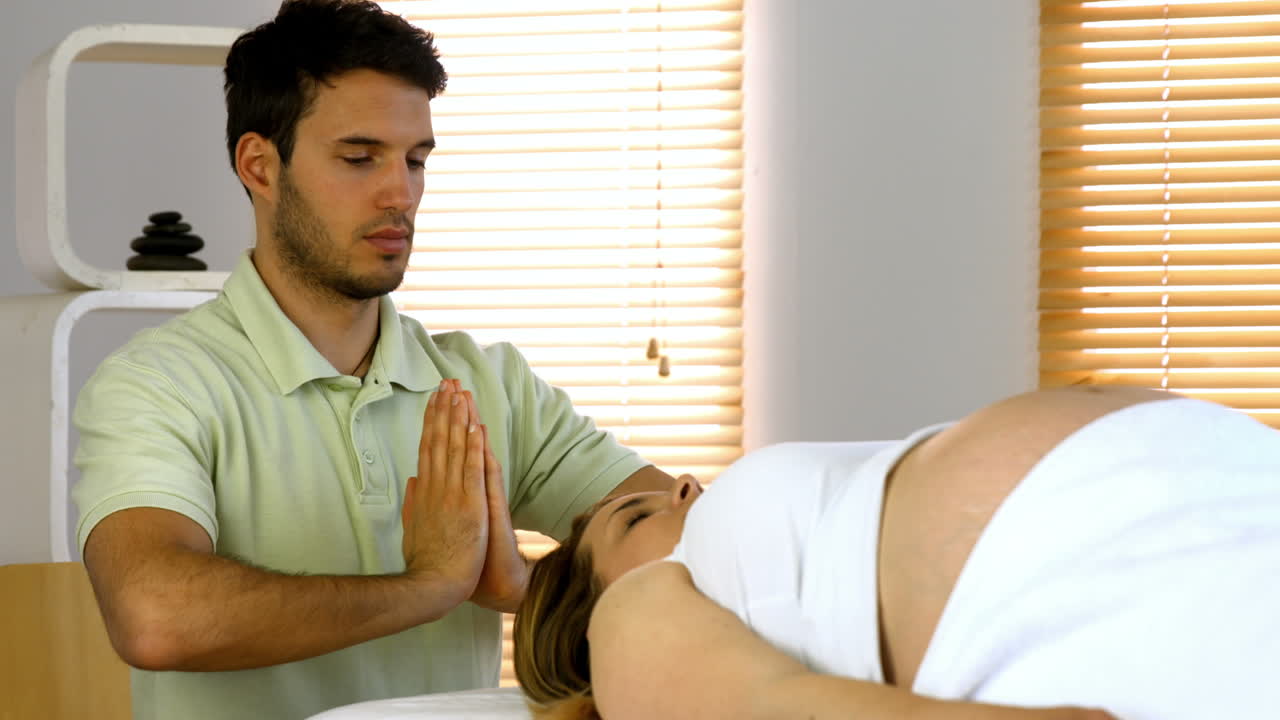 terapeuta realizando reiki en el paciente