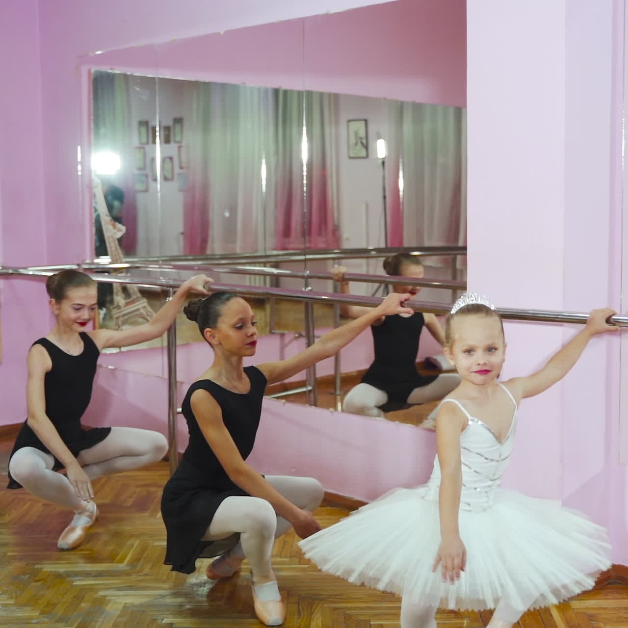 Beautiful ballerinas in black tutus at a ballet lesson. Lovely girls dance at ballet school.