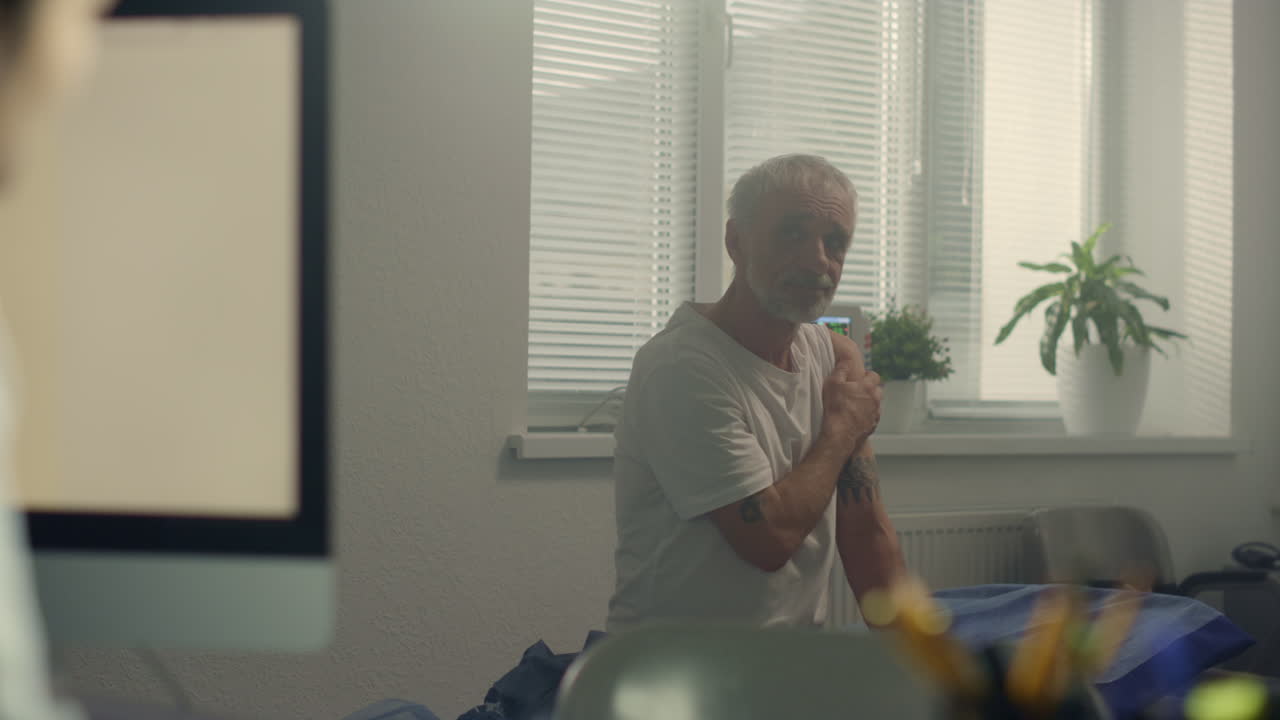 병원에서 백신 접종 후 노인 환자를 상담하는 의사가 앉아있는 책상