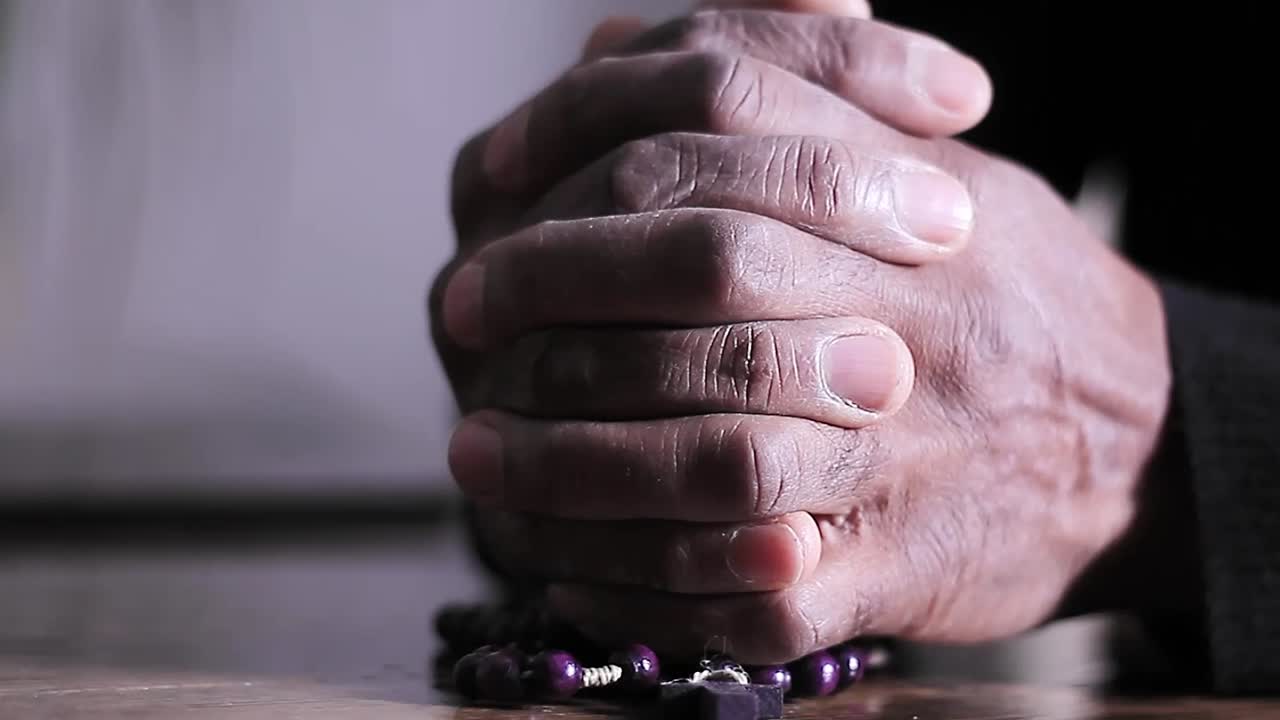 Vídeo de stock de manos rezando con cruz con personas