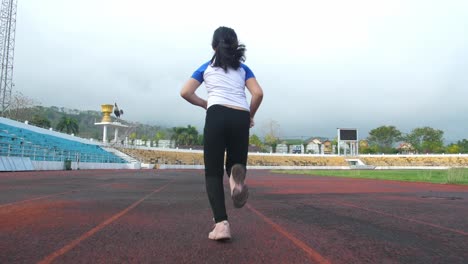 little girl jogging at stadium