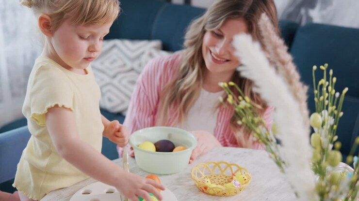 Young girl paints Easter egg with mother watching. Child focused, mother smiling warmly. Bright, cheerful home scene. Perfect for holiday, family, or craft-themed projects