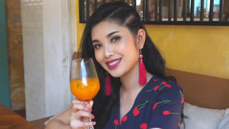 beautiful asian woman holding orange juice, slow motion