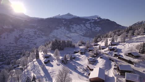 dolly sideways right to left pushing in over snow covered chalets in grindelwald on a blue bird winter day