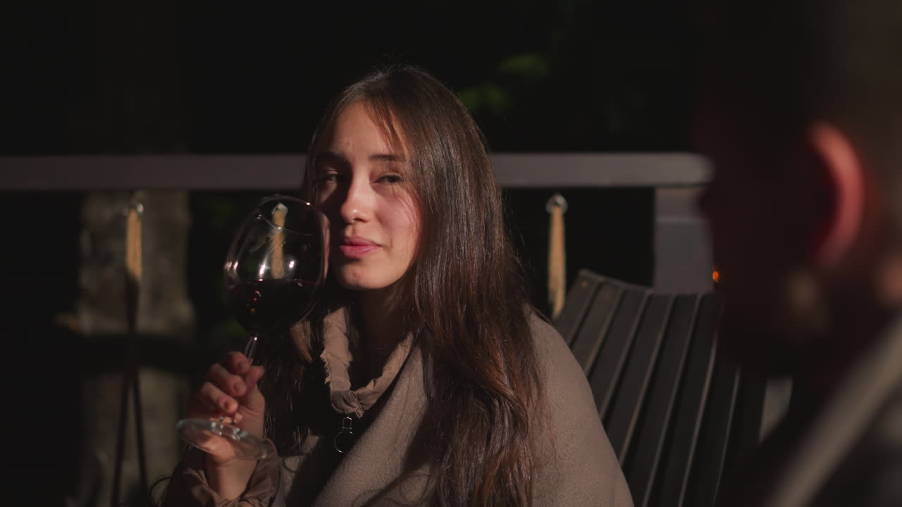 Couple enjoying wine on an outdoor patio at night