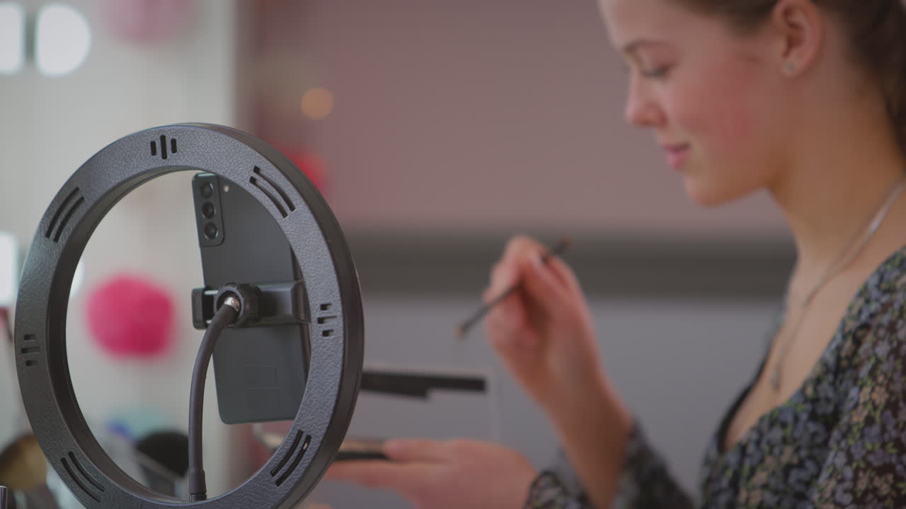 침실에서 십대 소녀 온라인 녹화 모바일 폰에서 메이크업 튜토리얼 - 느린 동작으로 촬영