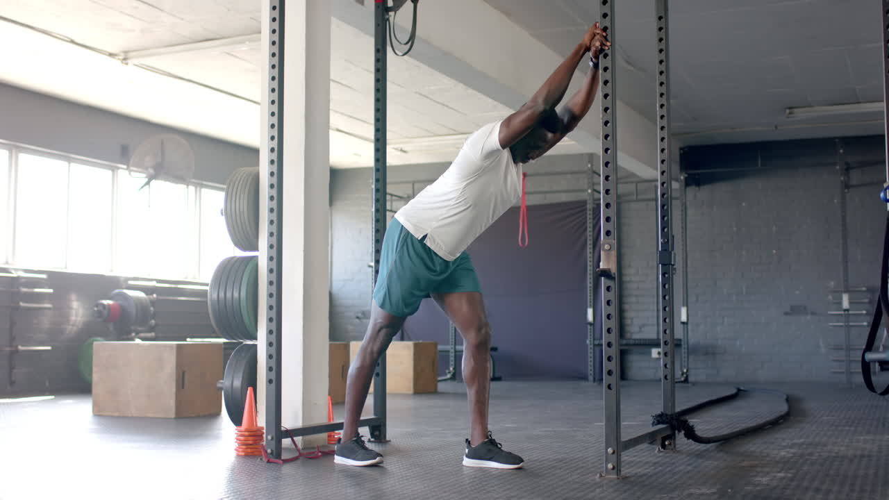 Young African American man training with resistance band in gym