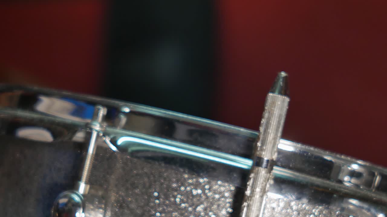 A detail shot of a drum being hit by the drumstick