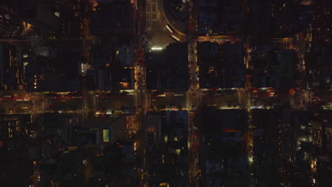 Aerial-birds-eye-overhead-top-down-descending-footage-of-traffic-in-midtown.-Flow-of-slowly-moving-cars-in-streets-between-high-rise-buildings.-Manhattan,-New-York-City,-USA