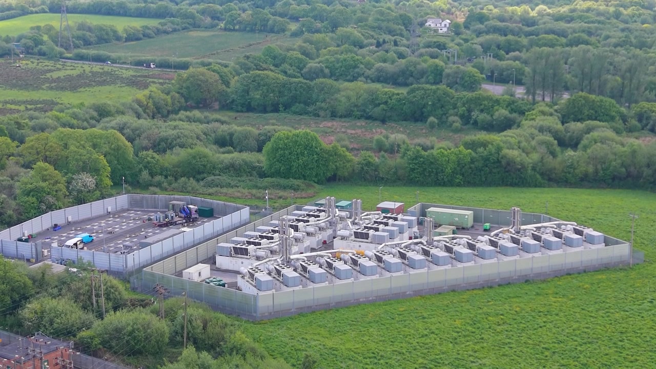 BESS Battery Storage in Construction with Modern Gas Peaking Plant with exhaust stacks, generators, cooling systems. Facility provides rapid-response electricity to the grid during peak demand.