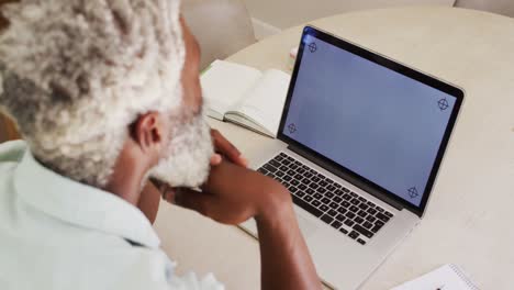 Afroamerikanischer-älterer-Mann-Am-Tisch,-Der-Videoanrufe-Mit-Einem-Laptop-Computer-Mit-Kopierplatz-Tätigt