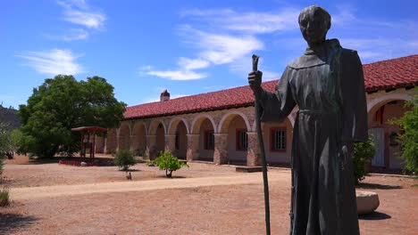 a statue of father junipero serra stands in front of a california mission 1