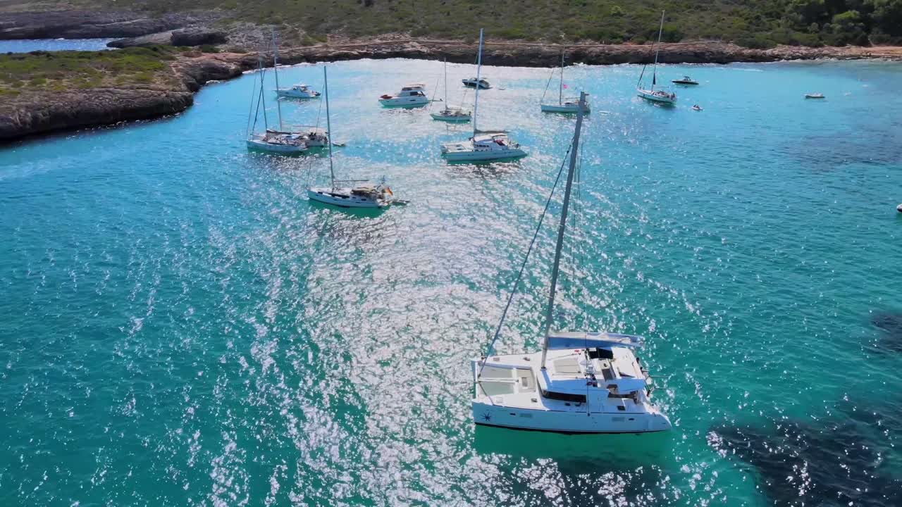 Experience the captivating beauty of Cala Varques in Mallorca as sailboats glide through crystal clear waters. This tranquil paradise offers a perfect escape for nature lovers and adventure seekers.
