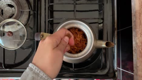 té de hierbas de manzana y canela en la tetera en el horno para verter en la taza vertiendo té caliente de la tetera de vidrio en la taza con hierbas y limón