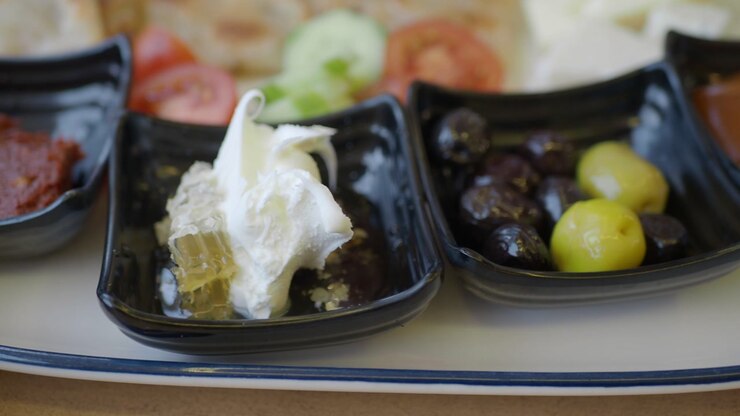 Close-up of a Traditional Turkish Breakfast Plate with Olives, Honeycomb, and Cream