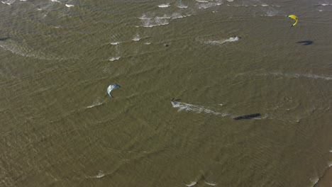 aerial footage of people kitesurfing.