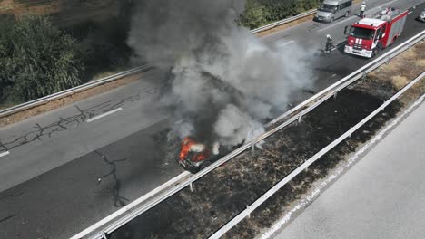 problem is on the road. traffic incident. firefighters extinguish burning car on highway following serious car accident on hot summer day aerial view. fire truck came to rescue. flow of cars on track