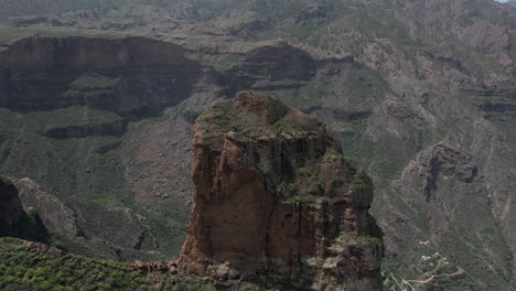 Toma-Aerea-En-La-Distancia-A-Roque-Palmes,-Divisando-Las-Montañas-Que-Lo-Rodean