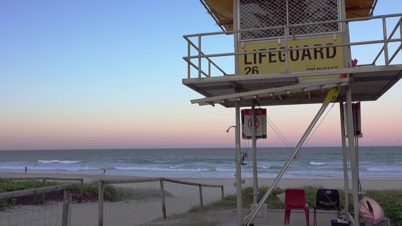 Looking past lifeguard tower 26 towards the ocean and colourful sky during sunset