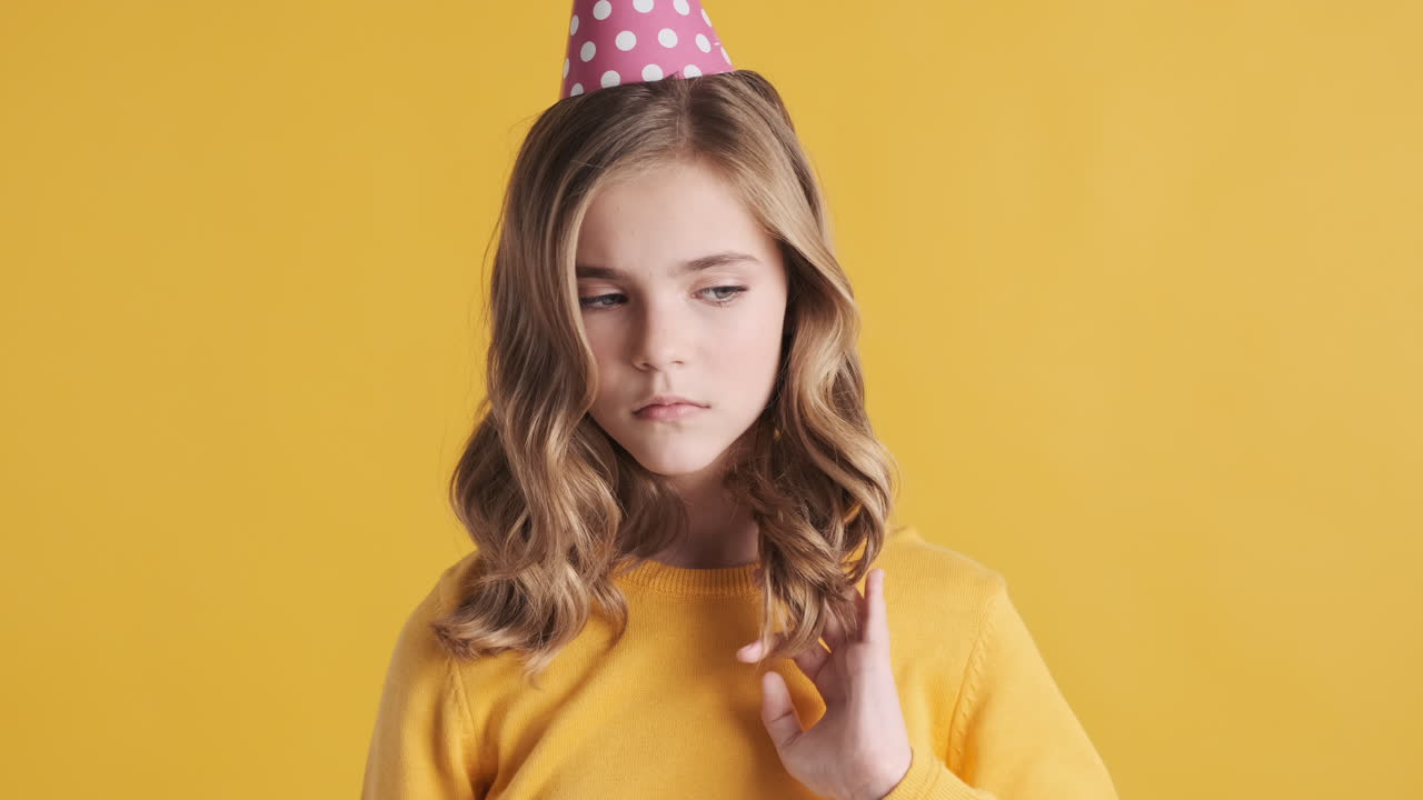 파티 모자를 입은 슬픈 십대 백인 소녀.