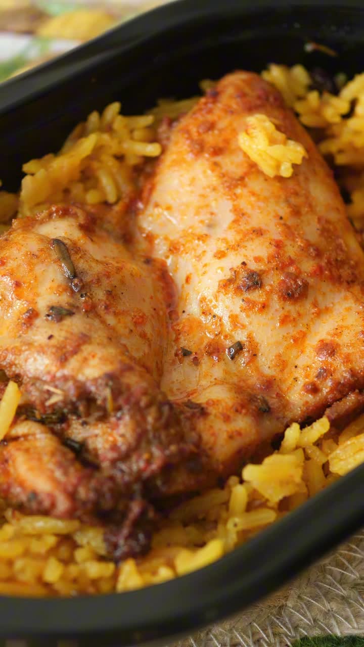 Primo piano di un pasto a base di pollo speziato e riso giallo