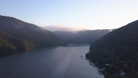 ascending aerial view from drone over water with view of shoreline, docks and boathouses