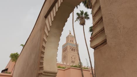 Reverse-zoom-Minaret-of-Koutoubia-Mosque-through-archway-in-Marrakesh,-Morocco