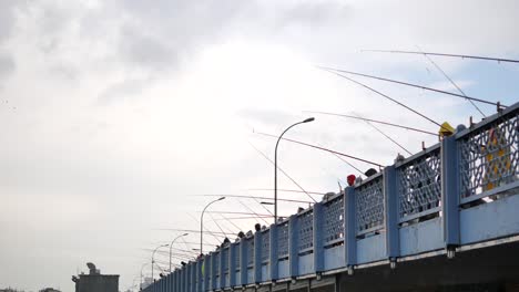 people fishing from a bridge on a cloudy day