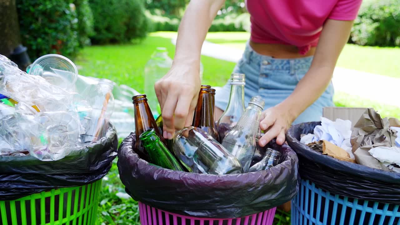 mujer reciclando botellas de vidrio y plástico