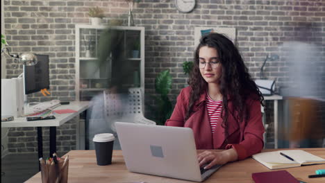 woman working on laptop in busy office