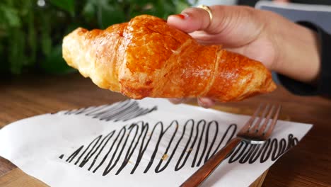 woman eating a croissant