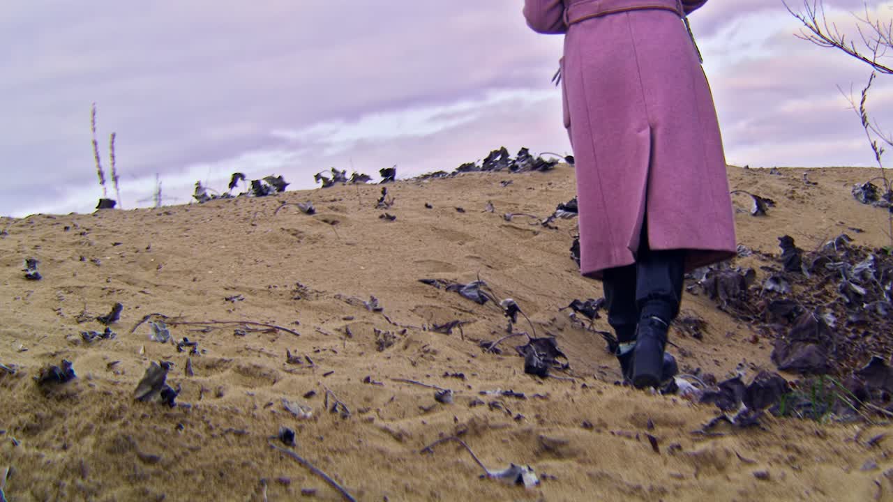 핑크색 코트를 입은 여자가 언덕을 고 있다