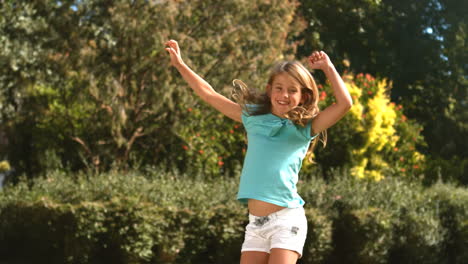 cute little girl jumping in her garden