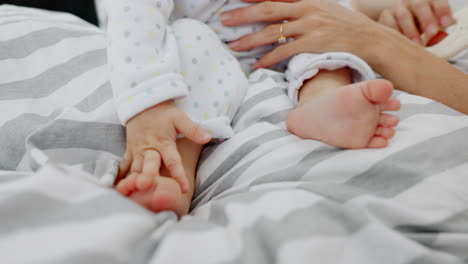 Baby-feet,-hands-and-mother-on-bed-in-home