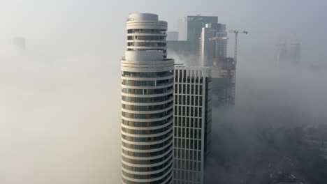 foggy city skyline with modern buildings under construction